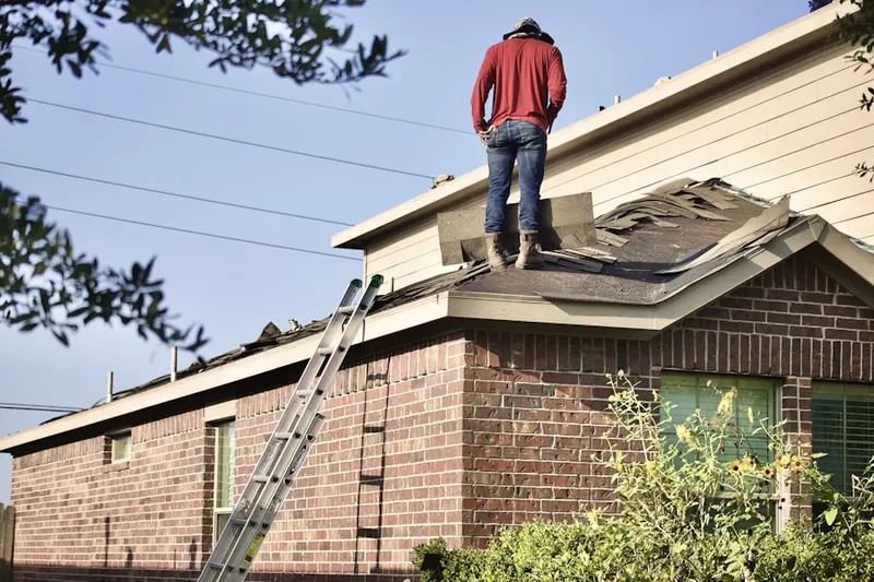 Professional roofer working on a residential roof in Palisades Estates